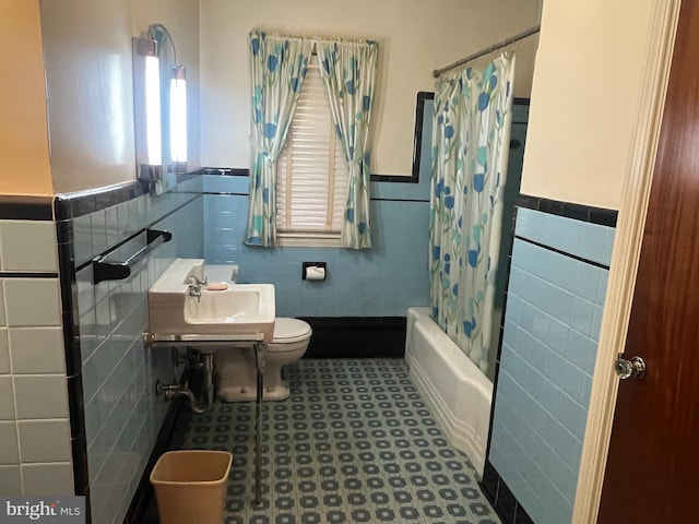 bathroom featuring tile walls, shower / tub combo, and toilet