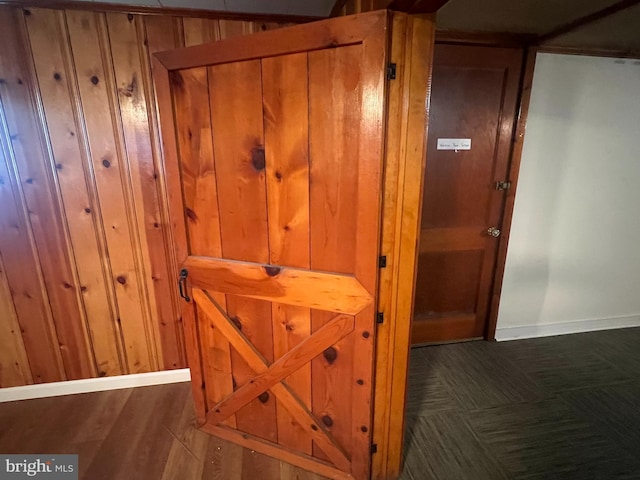 interior details with hardwood / wood-style floors and wood walls