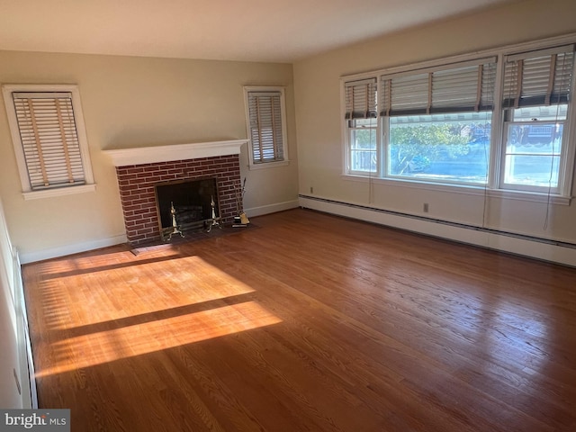 unfurnished living room featuring baseboard heating, wood-type flooring, and a fireplace