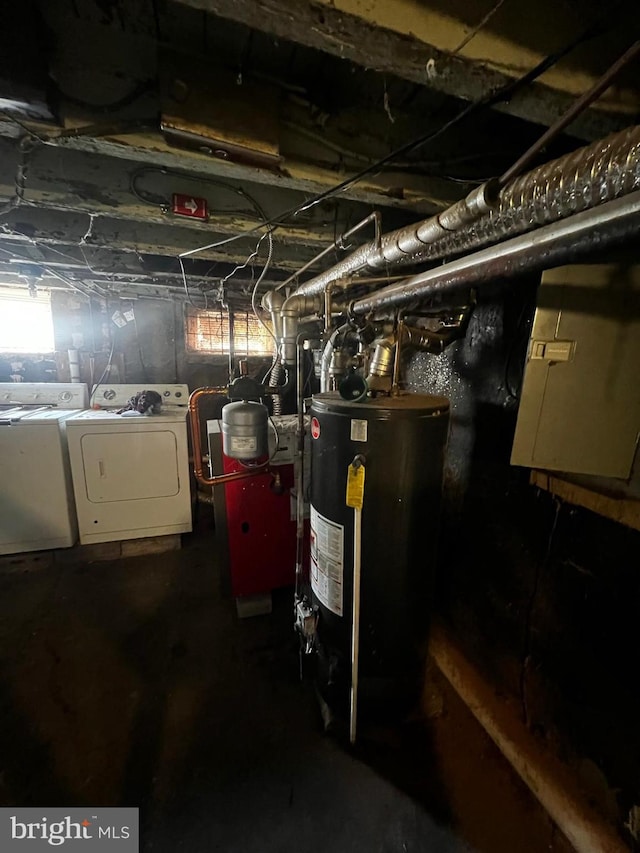 basement featuring gas water heater, electric panel, and washer and dryer