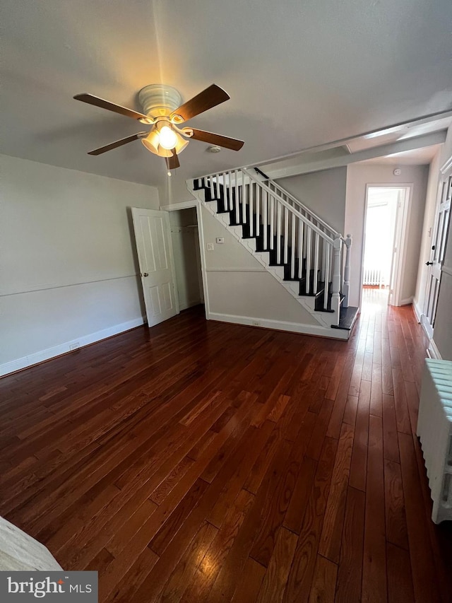 unfurnished living room featuring ceiling fan and dark hardwood / wood-style flooring