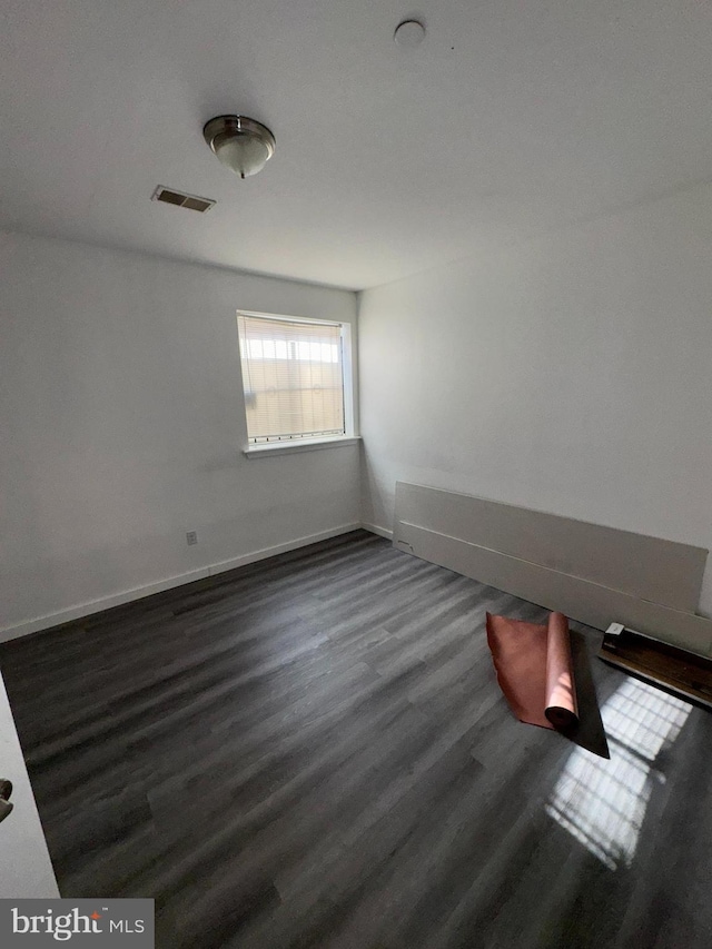 unfurnished room with dark hardwood / wood-style floors