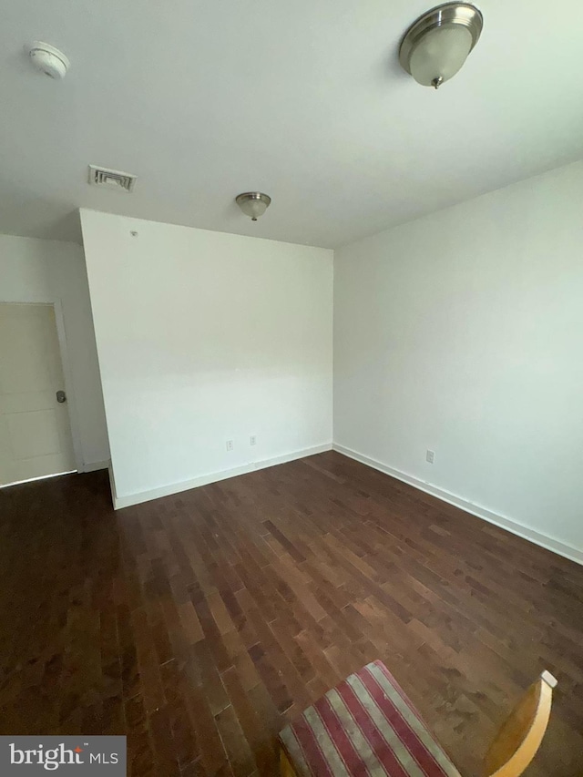 empty room with dark hardwood / wood-style flooring