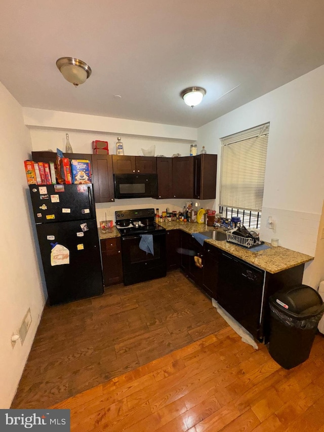 kitchen with sink, black appliances, and light hardwood / wood-style floors