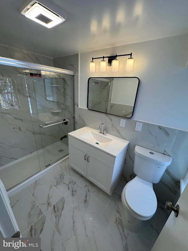 bathroom featuring vanity, a shower with door, and toilet