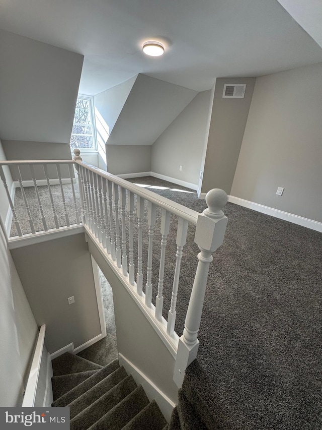 staircase featuring vaulted ceiling and carpet flooring