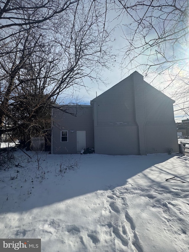 view of snow covered back of property