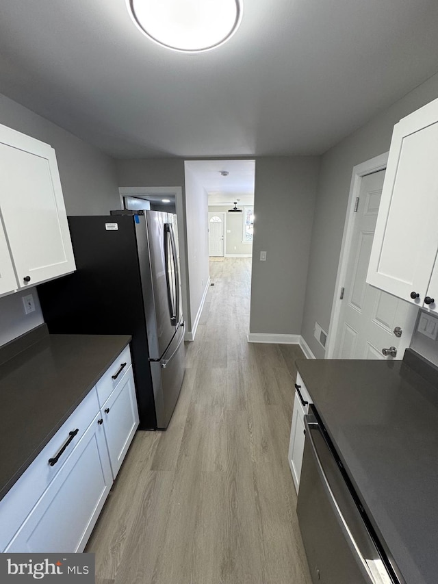 kitchen featuring stainless steel fridge, dishwashing machine, light wood-type flooring, and white cabinets