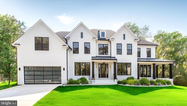 modern farmhouse featuring metal roof, concrete driveway, a front lawn, and a standing seam roof