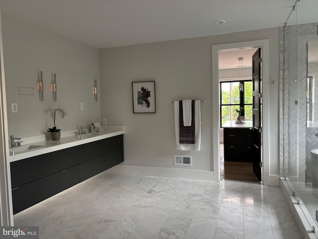 bathroom with a shower stall, double vanity, baseboards, and marble finish flooring