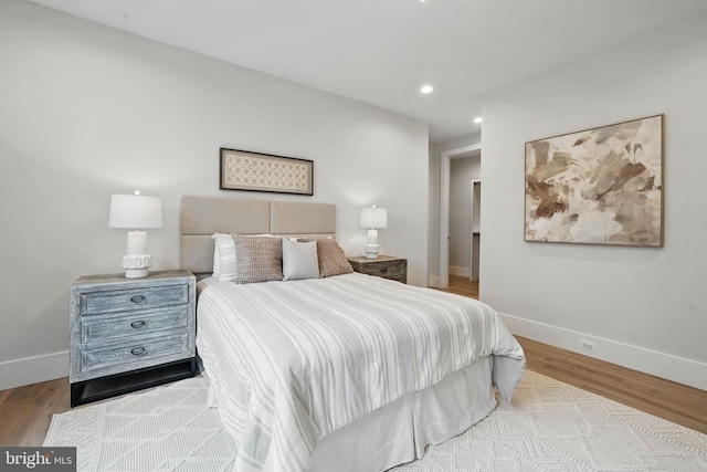 bedroom with wood finished floors, recessed lighting, and baseboards