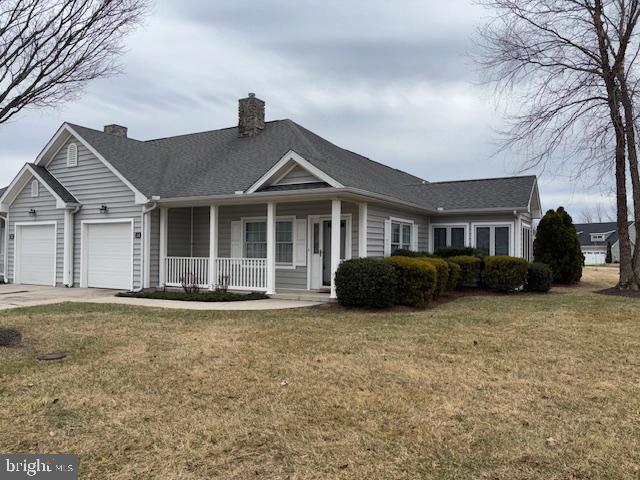 ranch-style home with a garage, a front lawn, and a porch