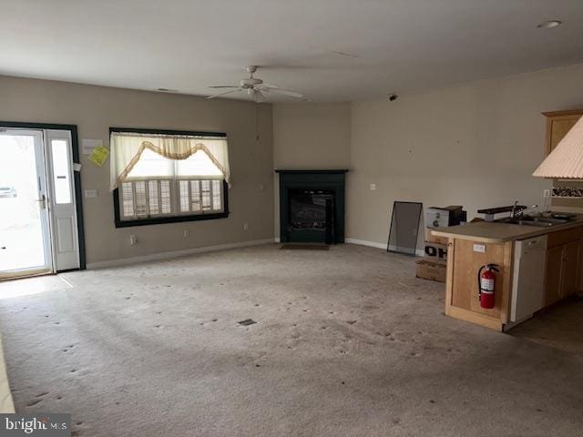 unfurnished living room featuring ceiling fan and sink