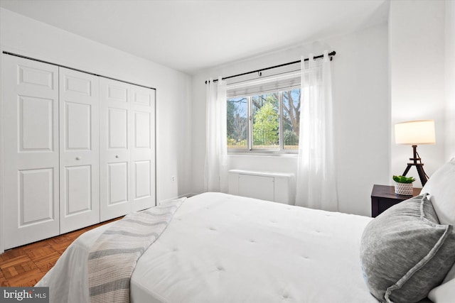 bedroom featuring parquet floors and a closet