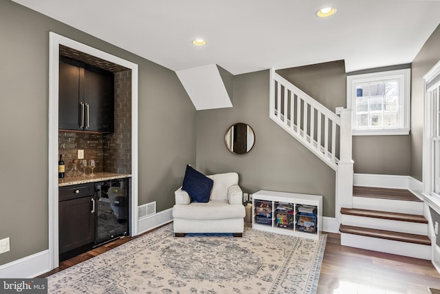 living area with beverage cooler, baseboards, wood finished floors, stairs, and recessed lighting