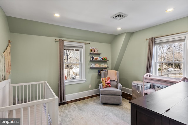 bedroom featuring baseboards, wood finished floors, visible vents, and recessed lighting