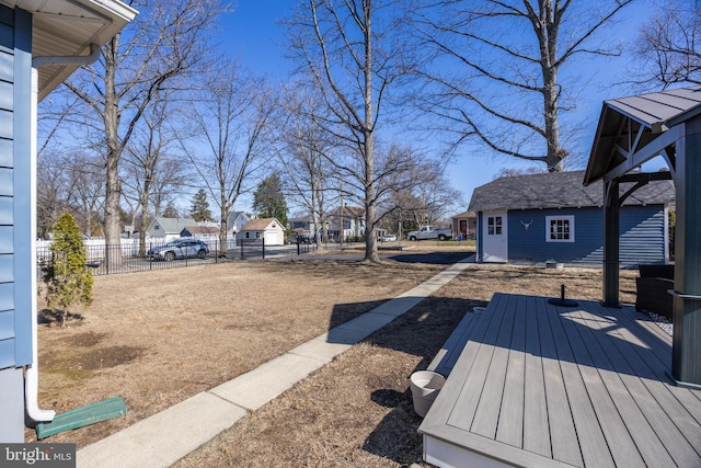 view of yard featuring a wooden deck, fence, and a residential view