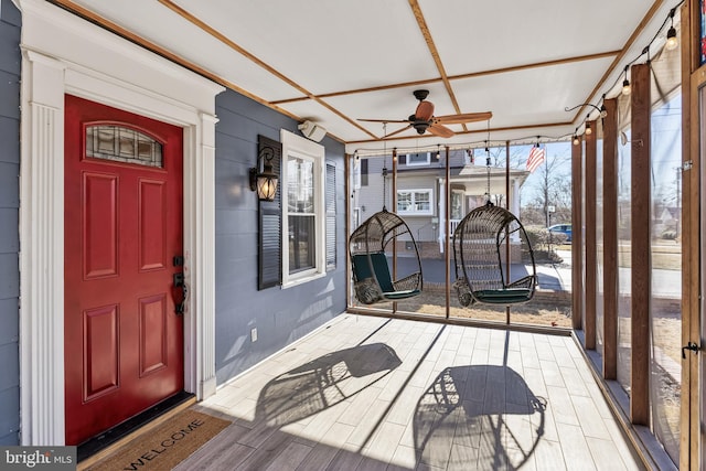 unfurnished sunroom with a ceiling fan