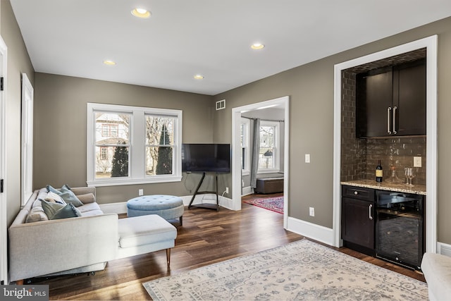 living room with wine cooler, a dry bar, recessed lighting, wood finished floors, and baseboards