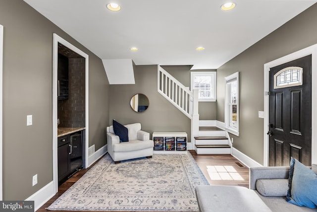 foyer featuring recessed lighting, wood finished floors, baseboards, and stairs