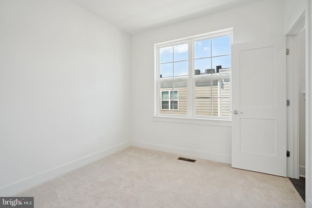 spare room featuring light colored carpet