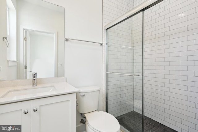 bathroom featuring vanity, an enclosed shower, and toilet