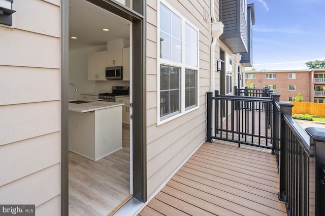 balcony with an outdoor kitchen and sink