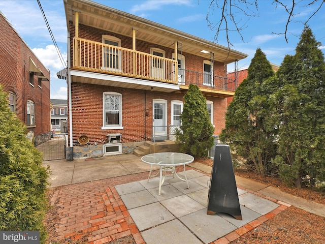 rear view of house featuring a balcony and a patio area