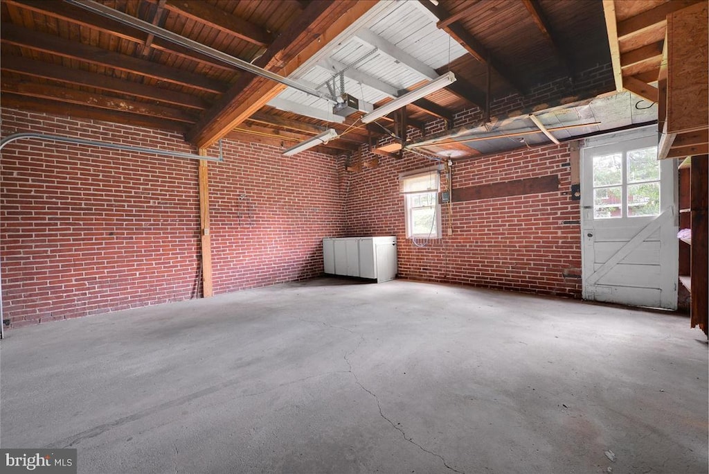 miscellaneous room with concrete flooring and brick wall