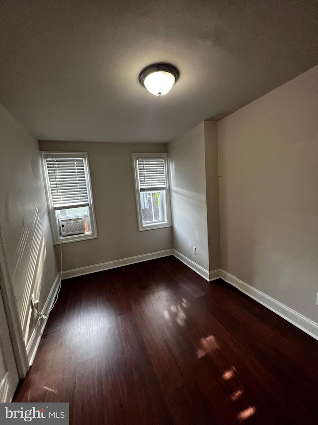 empty room featuring dark hardwood / wood-style floors and cooling unit