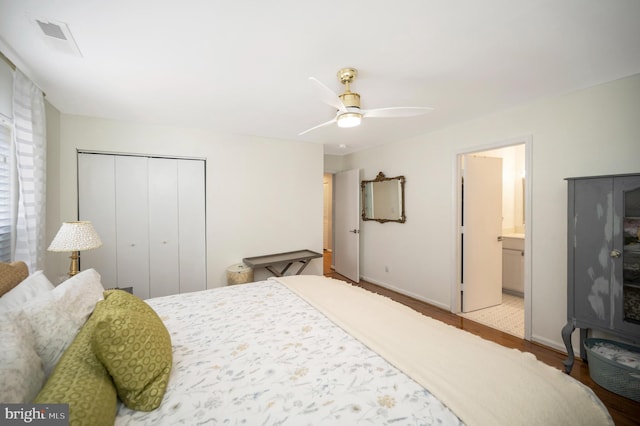 bedroom featuring ceiling fan, ensuite bath, light hardwood / wood-style floors, and a closet