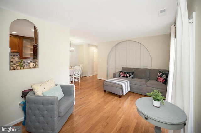 living room with a chandelier and light hardwood / wood-style floors