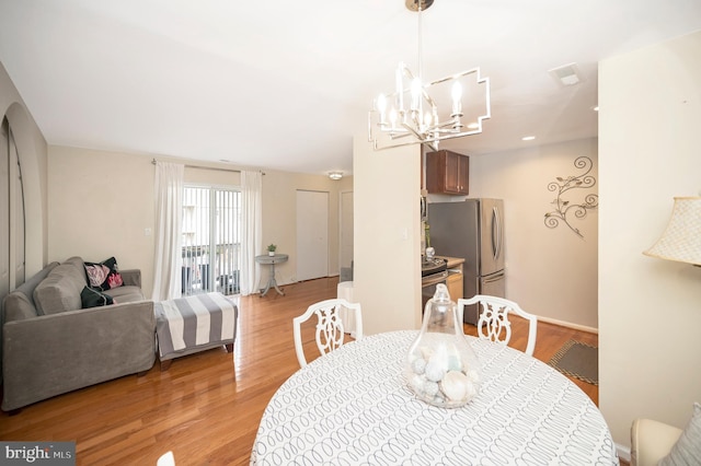 dining room featuring a notable chandelier and light wood-type flooring