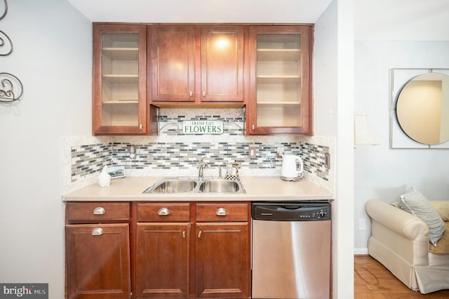 kitchen featuring tasteful backsplash, sink, hardwood / wood-style flooring, and dishwasher