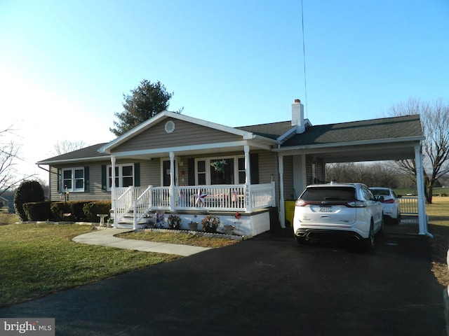 ranch-style home featuring a front lawn, a carport, and a porch