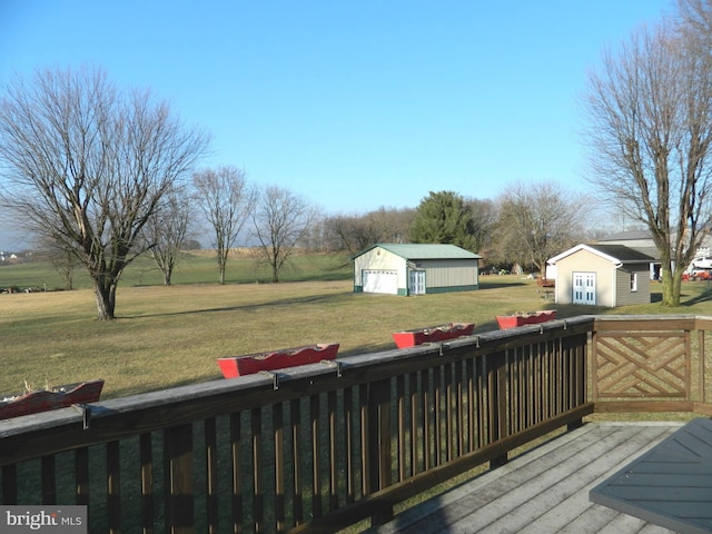 wooden deck with a garage, an outdoor structure, and a lawn