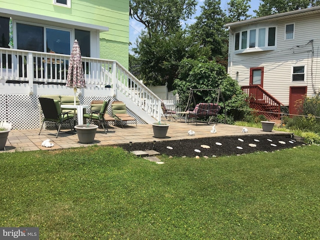 view of yard featuring a wooden deck, stairway, fence, and a patio area