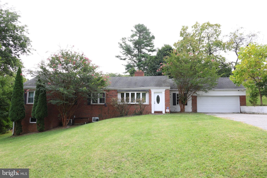 ranch-style home with a garage, brick siding, concrete driveway, a chimney, and a front yard