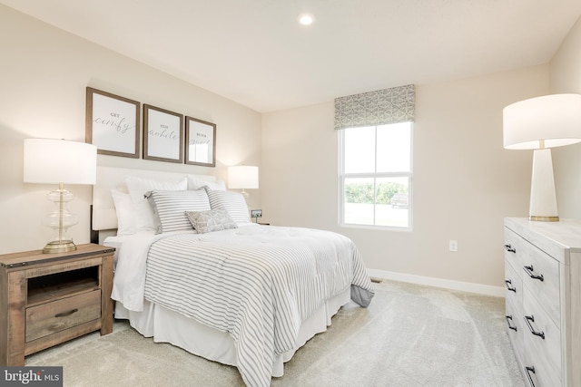 bedroom with baseboards and light colored carpet