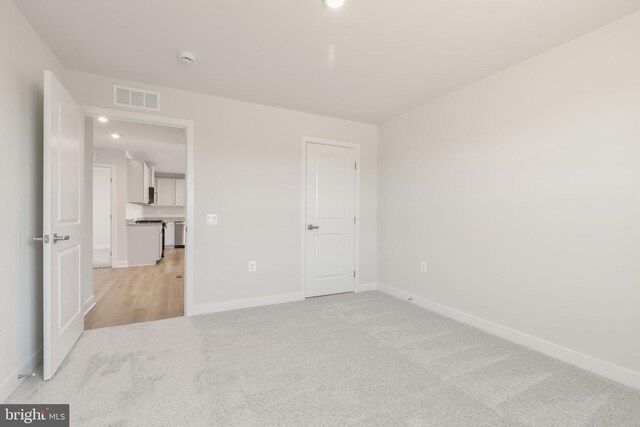 unfurnished bedroom featuring recessed lighting, baseboards, visible vents, and light carpet