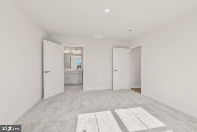 unfurnished bedroom featuring light colored carpet, connected bathroom, and baseboards