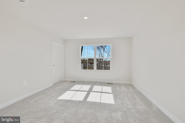 unfurnished room with carpet and baseboards