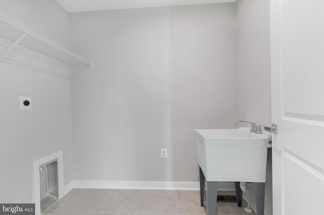 washroom featuring laundry area, light tile patterned floors, baseboards, and electric dryer hookup