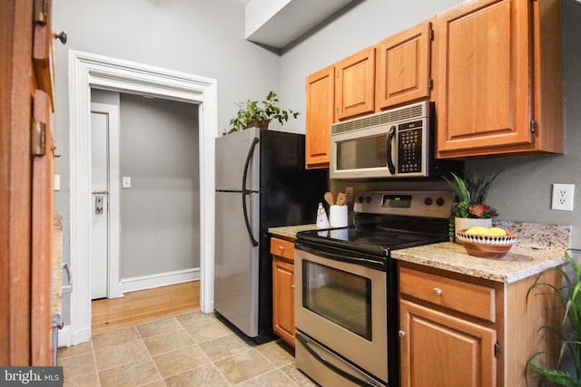 kitchen featuring light stone countertops and stainless steel appliances