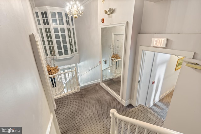 hallway with a chandelier and carpet