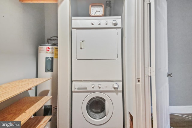 clothes washing area with water heater and stacked washer and clothes dryer