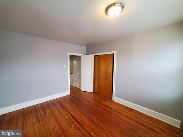 unfurnished bedroom featuring hardwood / wood-style floors and a closet