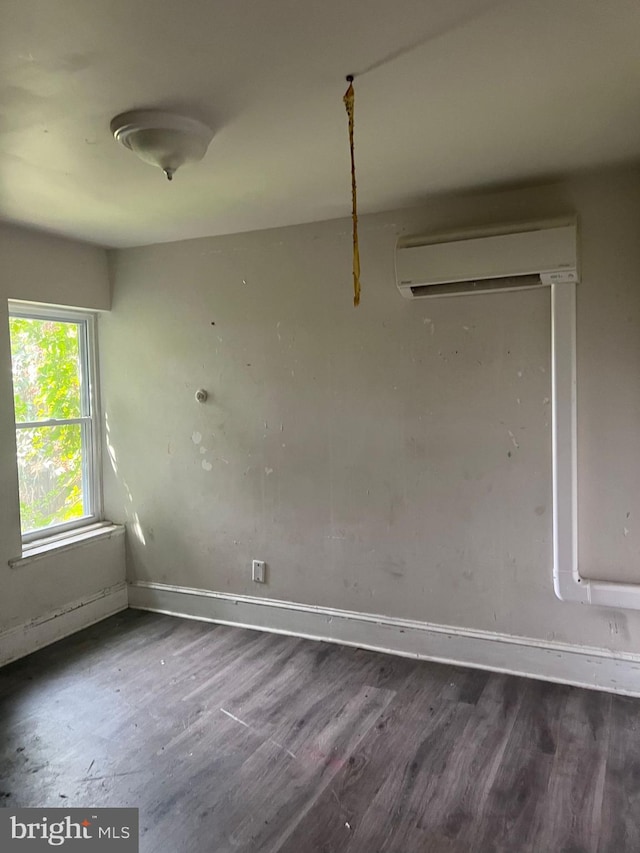 unfurnished dining area featuring dark wood-type flooring and a wall unit AC