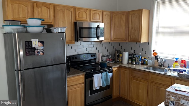 kitchen featuring sink, decorative backsplash, stainless steel appliances, and stone countertops