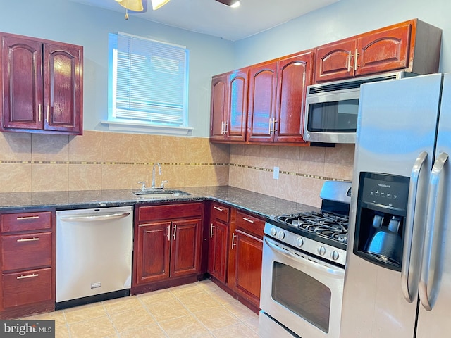 kitchen with tasteful backsplash, sink, dark stone counters, and appliances with stainless steel finishes